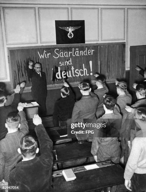 Teacher and his pupils give the Nazi salute, shortly after the population of the Saarland voted in a plebiscite to re-join Germany, January 1935....