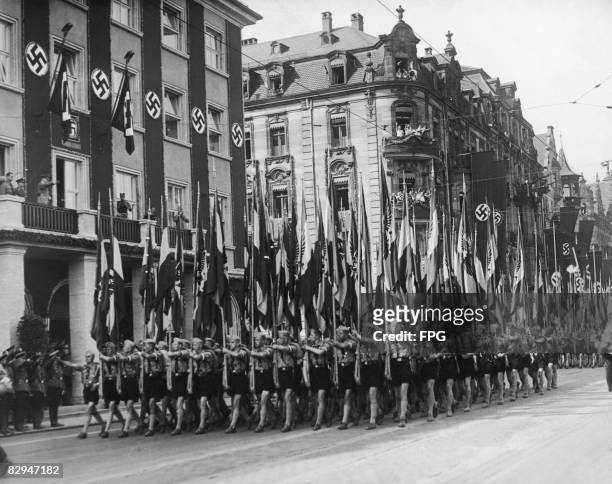 Nazi leader Adolf Hitler takes the salute as members of the Hitler Youth parade through Nuremberg with their standards, during the Nazi Congress, 7th...