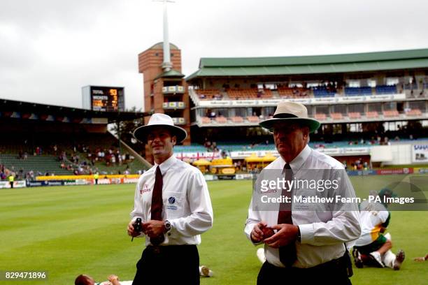 Umpire Darrell Hair and Simon Taufel leave the field after bad light stops play