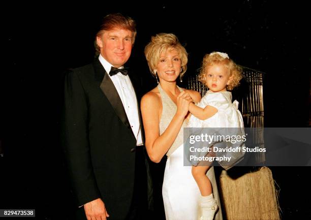 Portrait of married American couple, real estate developer Donald Trump and actress Marla Maples, and their daughter, Tiffany, as they pose together...