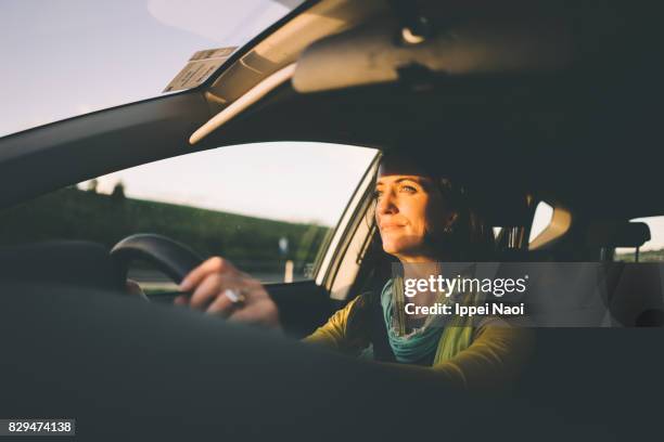 woman driving a car at sunset, melbourne - country road imagens e fotografias de stock