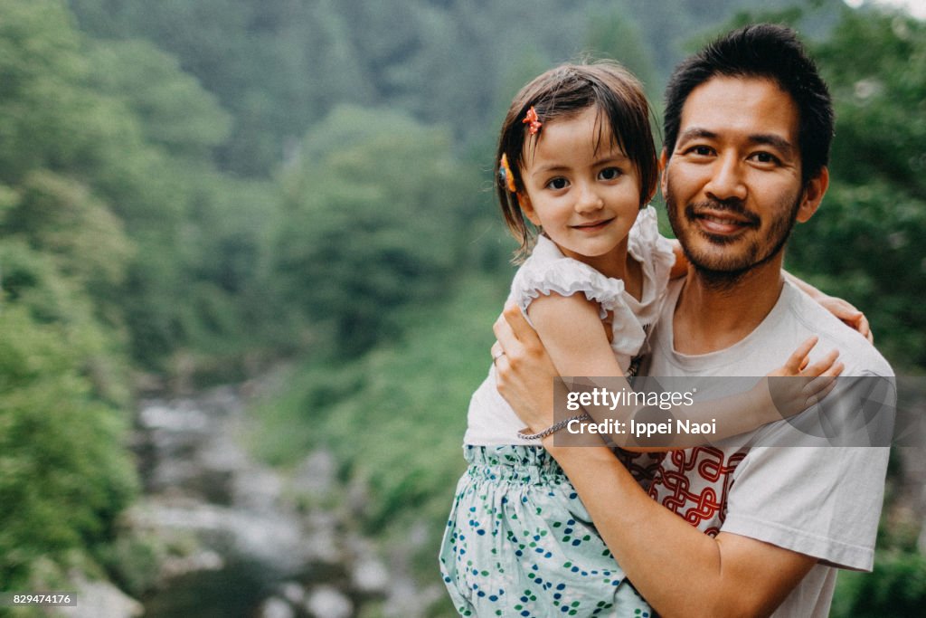 Portrait of father and daughter smiling at camera