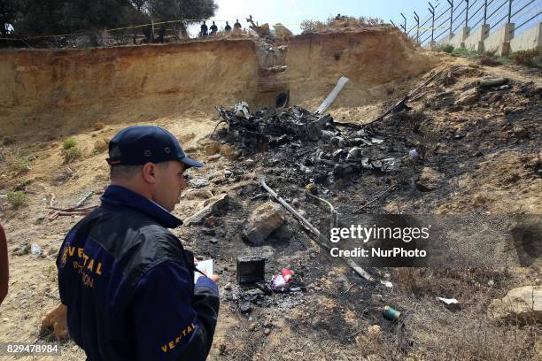 Algerian rescue workers inspect the site of a helicopter crash, Bel 206, belonging to Tassili Airlines, which killed four people, on August 10 in...