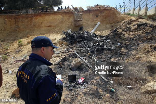 Algerian rescue workers inspect the site of a helicopter crash, Bel 206, belonging to Tassili Airlines, which killed four people, on August 10 in...