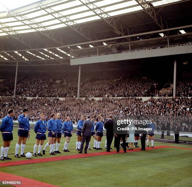 Queen Elizabeth II is introduced to the England team by FIFA President Sir Stanley Rous before the opening match of the Finals. The England players...