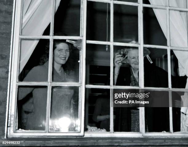 Lady Churchill raises a glass of champagne in toast to her husband's 86th birthday as she stands at the window of their home in Hyde Park Gate,...