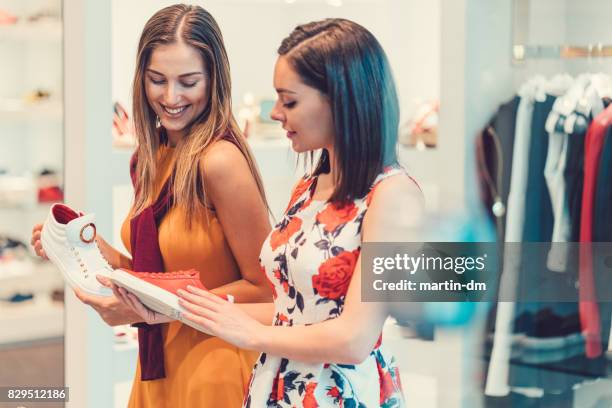 women buying sneakers in the shoe store - shopping friends family stock pictures, royalty-free photos & images