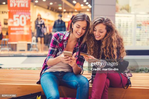 smiling women shopping online with credit card - family mall stock pictures, royalty-free photos & images