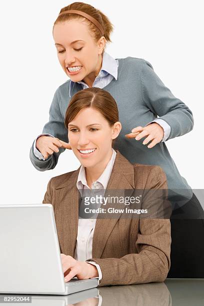businesswoman working on a laptop with her colleague try to strangle behind her - women being strangled stock pictures, royalty-free photos & images
