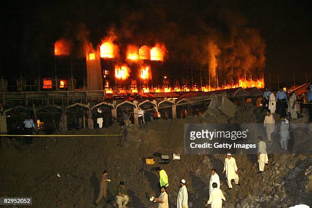 People watch as smoke and fire fills the sky after a suicide truck bombing at the Marriott Hotel September 20, 2008 in Islamabad, Pakistan. The...