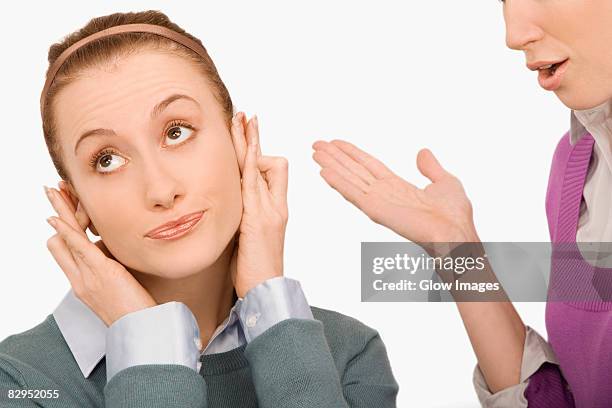 close-up of a businesswoman covering her ears with fingers - vingers in de oren stockfoto's en -beelden