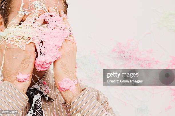 close-up of a businessman covered with spray string - party string stock pictures, royalty-free photos & images