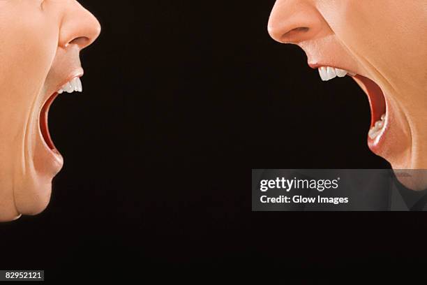 close-up of two young men shouting at each other - mouth shouting stock pictures, royalty-free photos & images