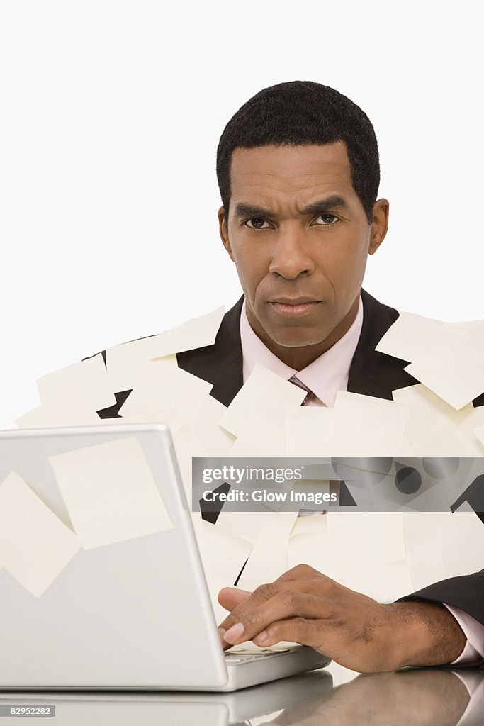 Businessman working on a laptop and covering with adhesive notes