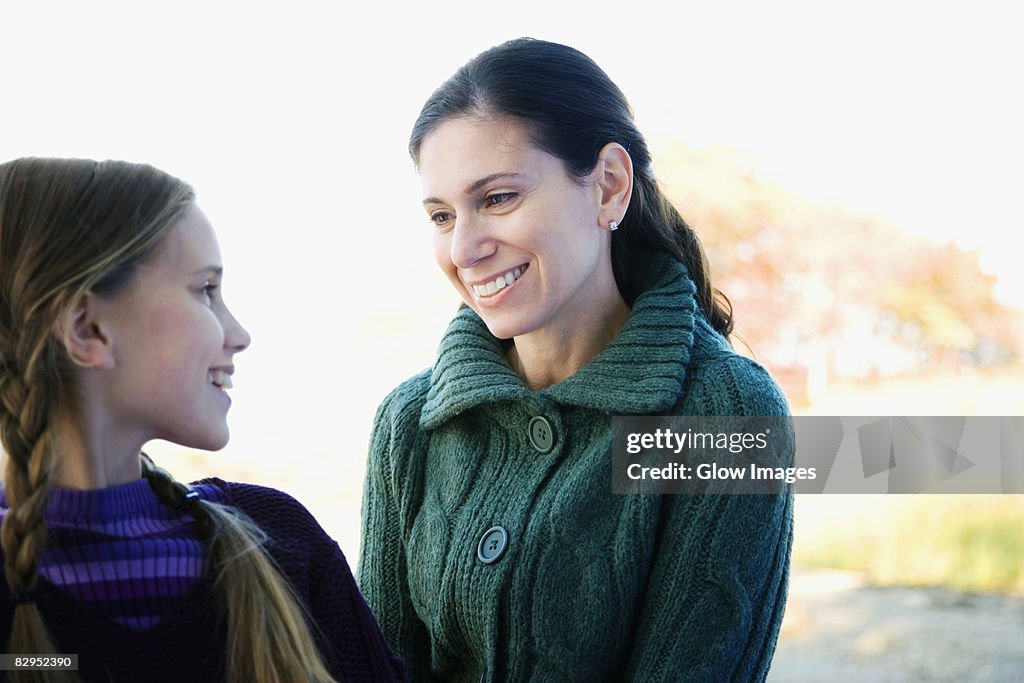 Mid adult woman looking at her daughter and smiling