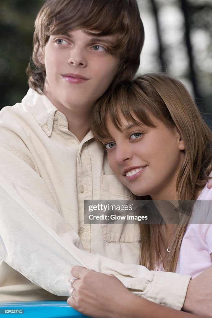 Close-up of a teenage couple embracing each other