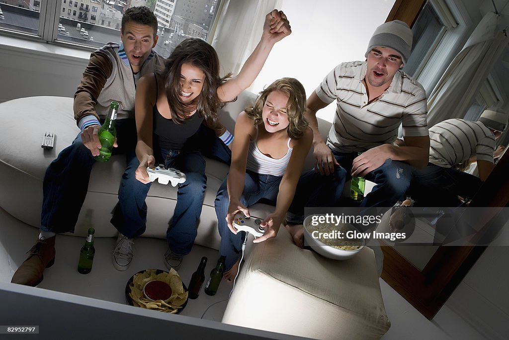 Two young couples playing video game and smiling