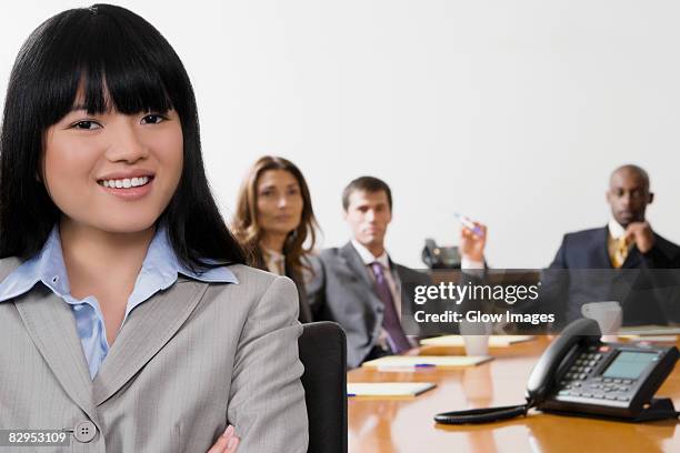 portrait of a businesswoman with her colleagues in the background - portrait man suit smiling light background stock pictures, royalty-free photos & images