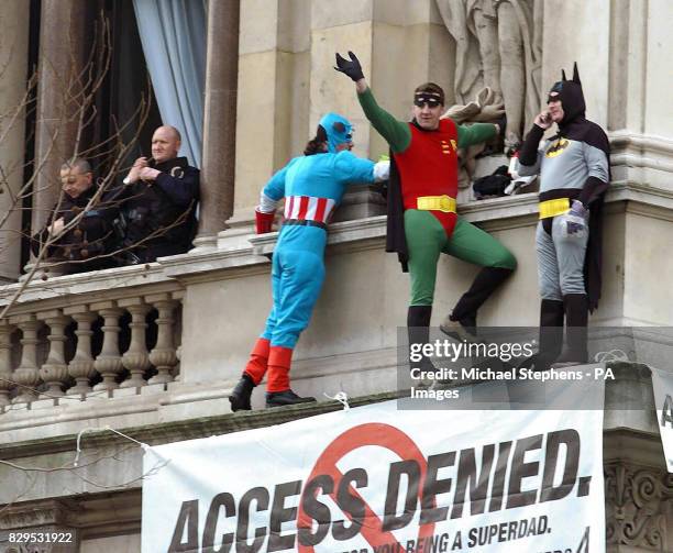 Three members of the Fathers 4 Justice dressed as superheroes Captain America, Batman and Robin on a ledge of the Foreign Office, above the junction...