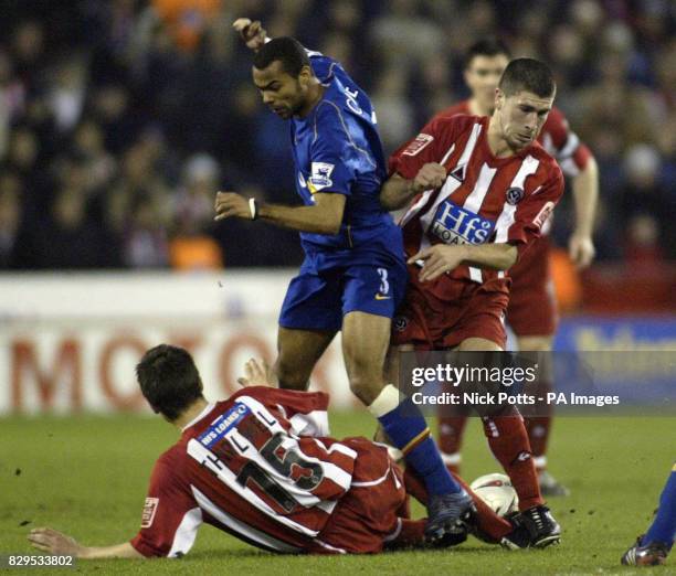 Sheffield United's Nick Montgomery and Paul Thirwell tussle for the ball with Arsenal's Ashley Cole.