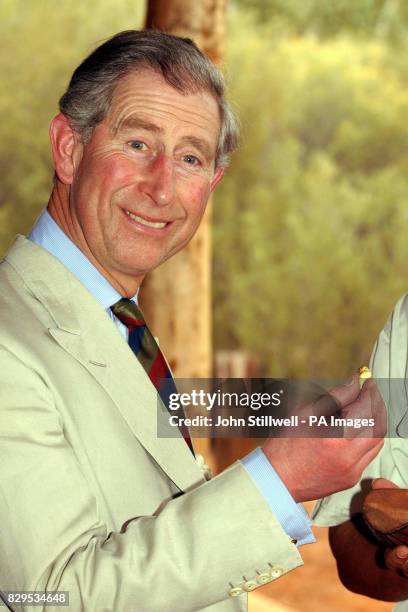 The Prince of Wales holds but refuses to eat a Witchety bug during his visit to the Desert Park on the outskirts of Alice Springs.