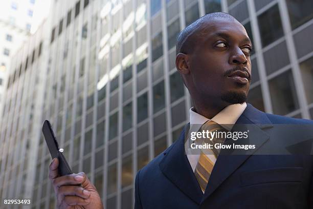 low angle view of a businessman using a mobile phone - feature phone stockfoto's en -beelden