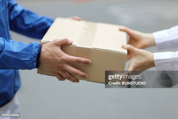 delivery person with packages,close up - giving a box ストックフォトと画像