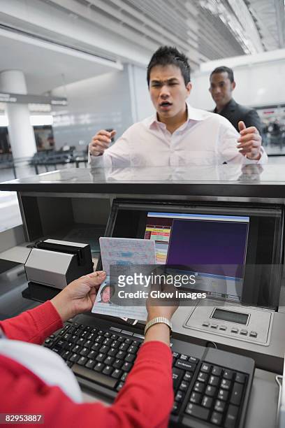 businessman looking angry at a ticket counter in an airport - passport open stock pictures, royalty-free photos & images