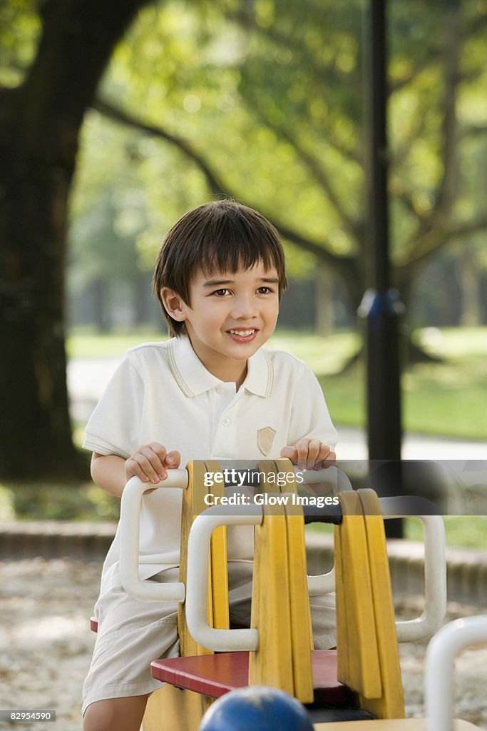 Portrait of a boy sitting on a ride and smiling in a park