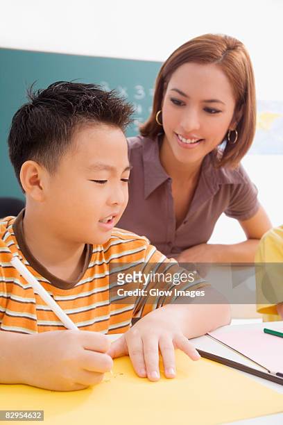 female teacher teaching her student in a classroom - 9 hand drawn patterns stock pictures, royalty-free photos & images
