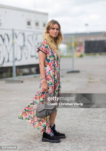 Guest wearing a dress with floral print outside Ganni on August 10, 2017 in Copenhagen, Denmark.