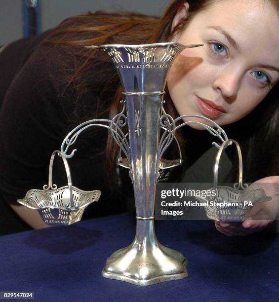 Frances Godden of Bonhams auction house inspects a silver table centrepiece from the a la carte restaurant on the White Star liner Titanic which sunk...