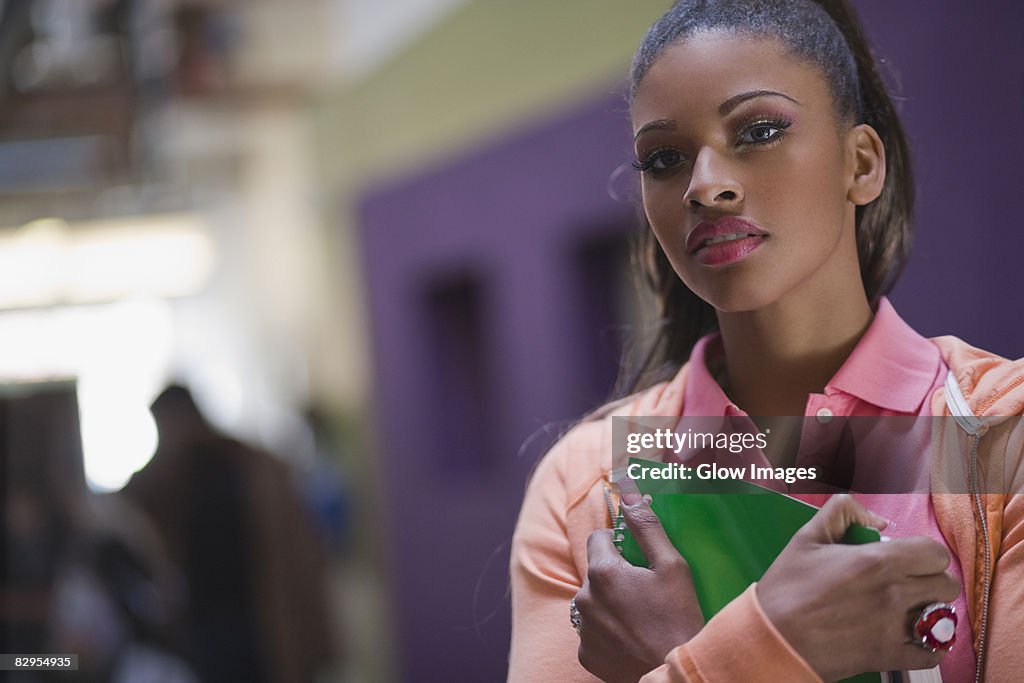 Portrait of a young woman holding a textbook