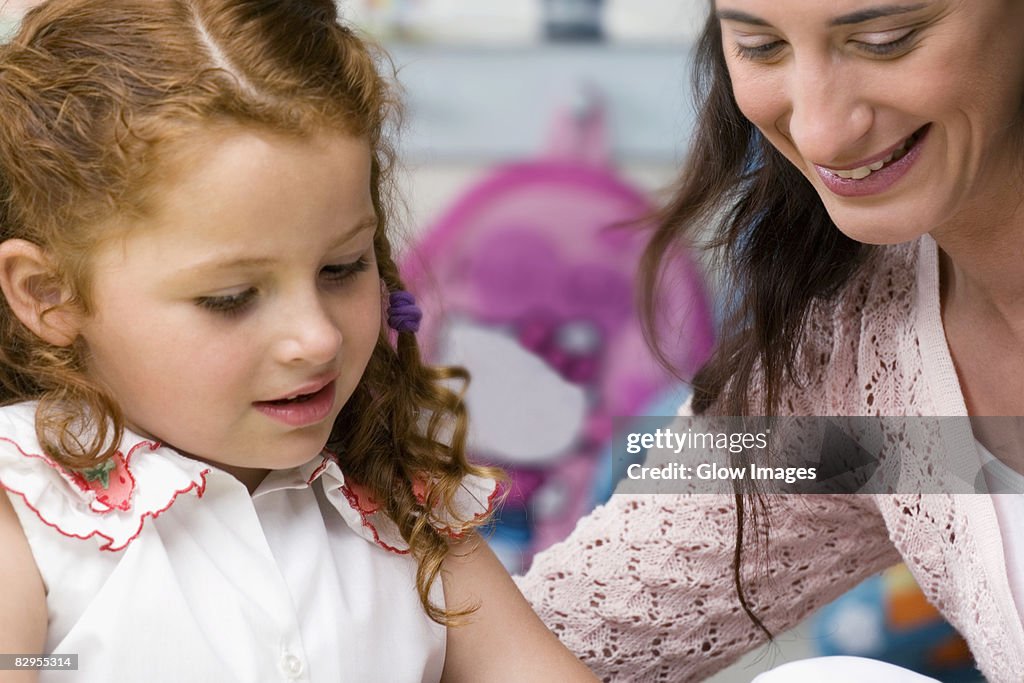 Female teacher teaching her student in a classroom