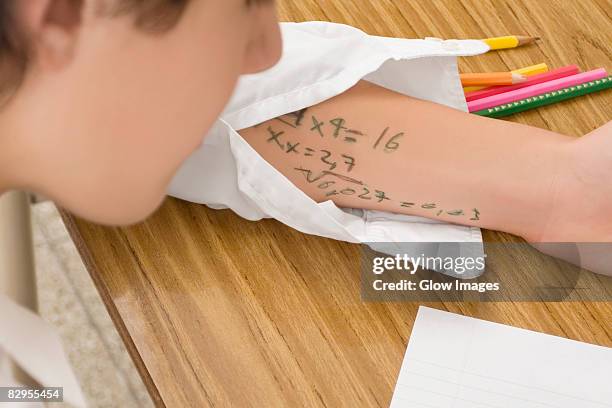 close-up of a schoolboy copying in an examination - desonestidade imagens e fotografias de stock