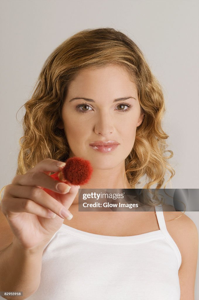 Portrait of a young woman holding blush brush