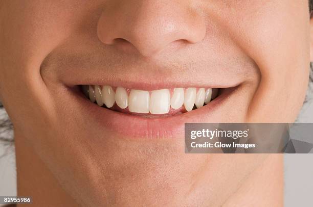 close-up of a young man smiling - human mouth stock pictures, royalty-free photos & images