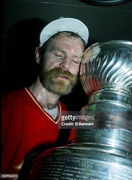 Canadian professional ice hockey player Lanny McDonald of the Calgary Flames hugg the Stanley Cup after his team defeated the Montreal Canadiens in...