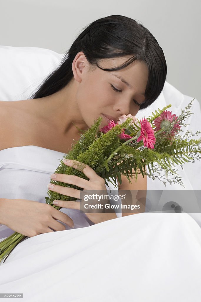 Young woman smelling a bouquet of flowers