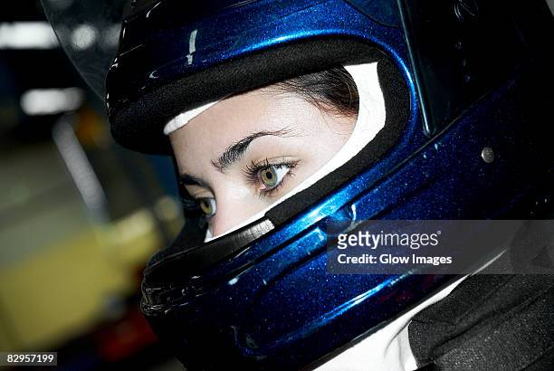 close-up of a female race car driver wearing a crash helmet - piloto de coches de carrera fotografías e imágenes de stock