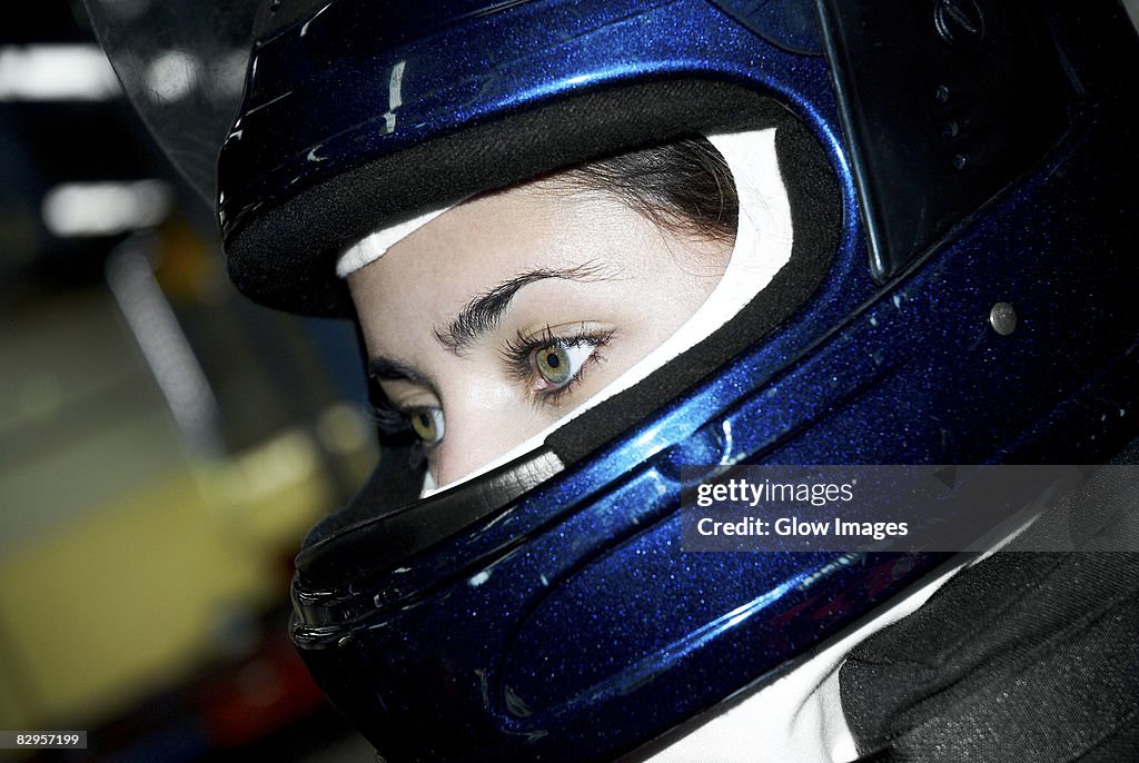 Close-up of a female race car driver wearing a crash helmet