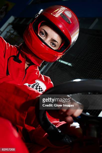 portrait of a female go-cart racer sitting in a sports car - pilota di auto da corsa foto e immagini stock