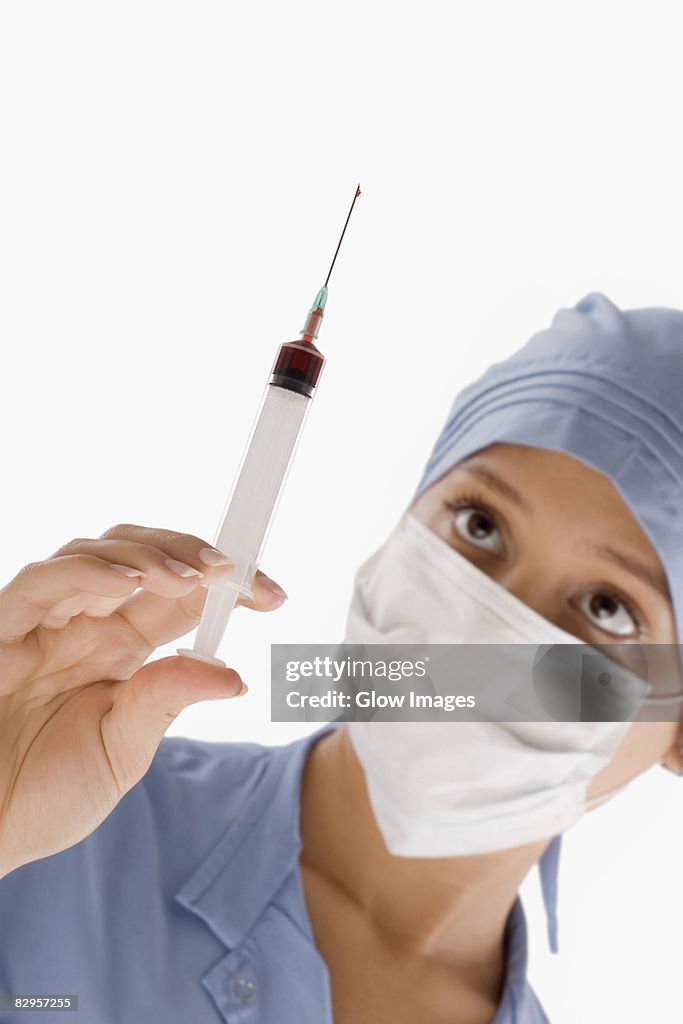 Close-up of a female surgeon holding a syringe