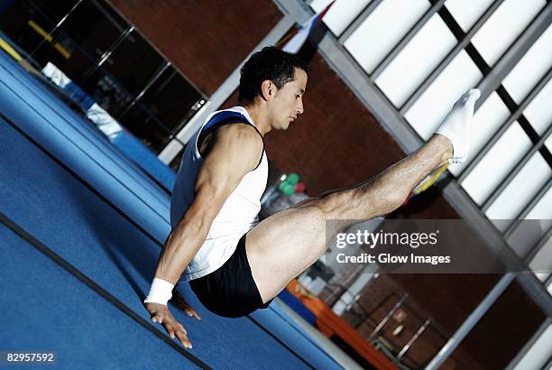 side profile of a male gymnast balancing on his hands - floor gymnastics stock pictures, royalty-free photos & images