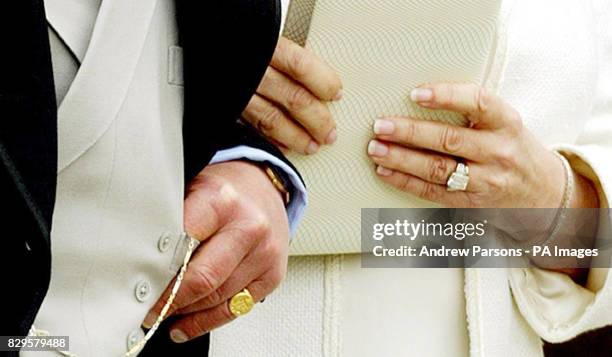 The Prince of Wales and his wife the Duchess of Cornwall display their rings as they leave Windsor Guildhall.