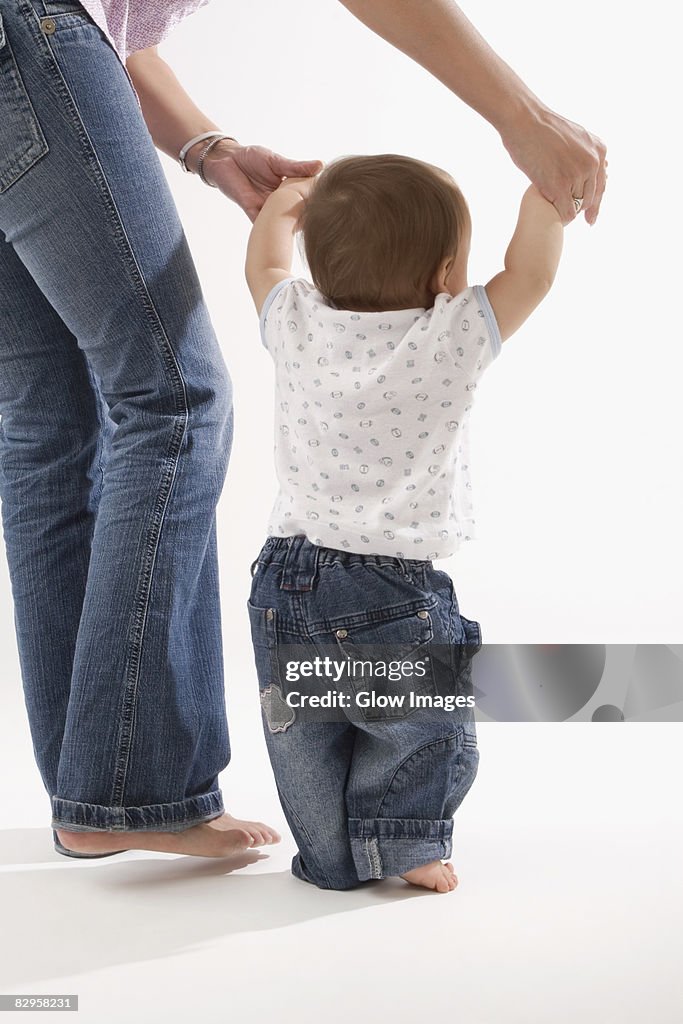 Low section view of a woman walking with her baby boy