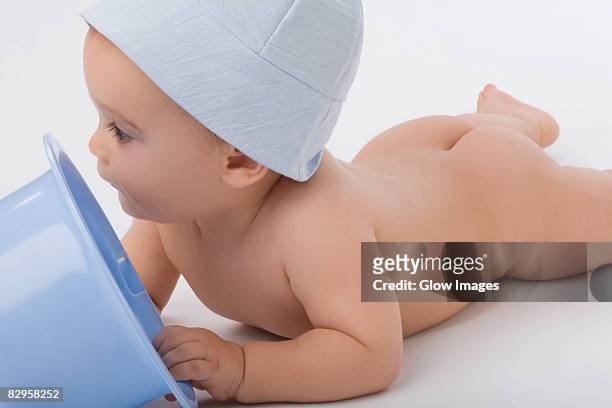close-up of a baby boy playing with a bucket - cute bums stockfoto's en -beelden