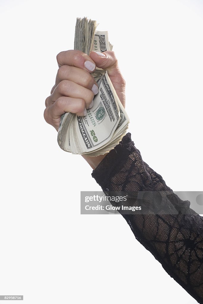 Close-up of a person's hand holding US dollar bills