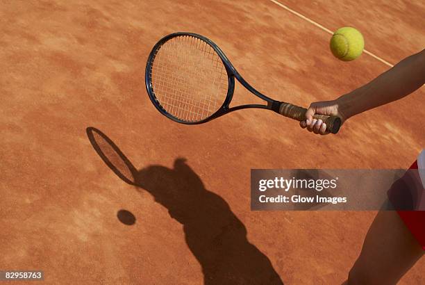 mid section view of a female tennis player playing - tennisschläger stock-fotos und bilder