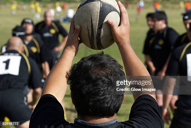 rear view of a man holding a rugby ball - rugby union fotografías e imágenes de stock